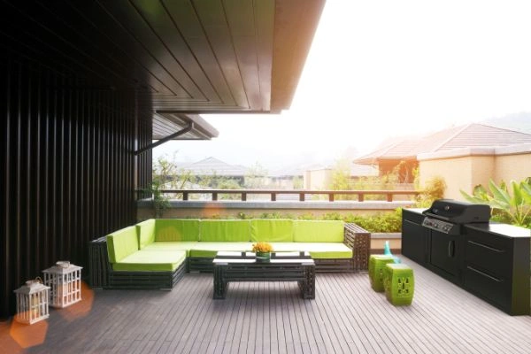 Bucatarie exterior BBQ KItchen pe terasa cu coltar  si masuta langa ea.
